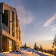 Experience the ultimate winter retreat in this stunning modern cabin, nestled on a snow-covered slope with breathtaking sunset views.