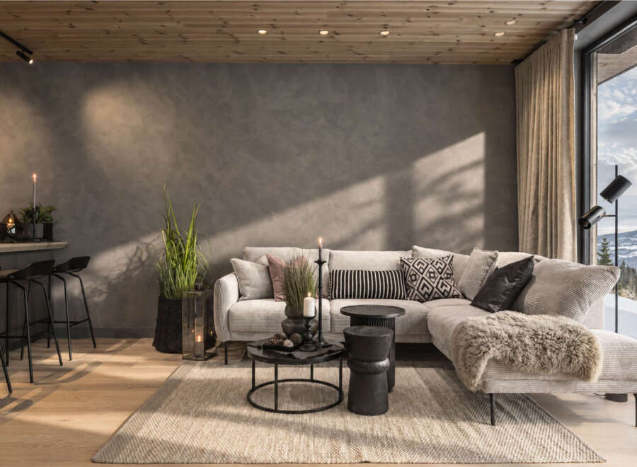 Experience modern mountain living in this stunning living room, featuring a plush sectional sofa adorned with decorative pillows and a cozy throw.