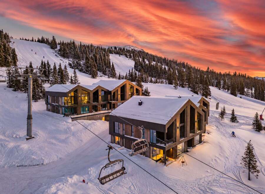 Experience luxury mountain living in these stunning modern chalets, perfectly situated on a ski slope with breathtaking sunset views.