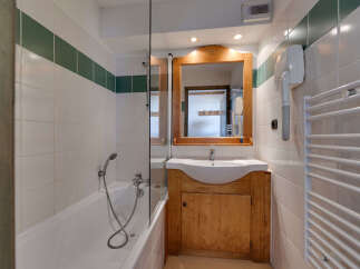This charming bathroom features a bathtub with a showerhead, perfect for relaxing after a long day.
