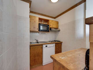 This charming kitchen features warm wooden cabinetry and a tiled backsplash, creating a cozy and functional space.