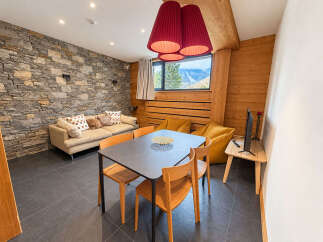 Experience cozy mountain living in this charming apartment, featuring a rustic stone accent wall and warm wooden paneling.