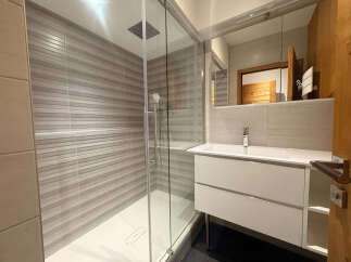 Experience modern comfort in this beautifully appointed bathroom, featuring a spacious walk-in shower with sleek horizontal tiling.