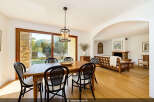 Experience elegant dining in this beautifully appointed space, featuring a warm wooden table and stylish cane-backed chairs.