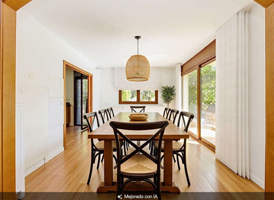 This spacious dining room features a large wooden table surrounded by eight chairs, perfect for family gatherings.