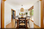 This spacious dining room features a large wooden table surrounded by eight chairs, perfect for family gatherings.