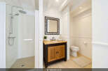 This bright and airy bathroom features a spacious walk-in shower with a modern chrome showerhead and a separate handheld sprayer.