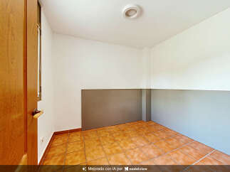 This empty room features warm-toned tiled flooring and neutral-colored walls, offering a blank canvas for customization.