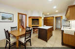 This spacious kitchen boasts a large brick fireplace, perfect for cozy evenings.