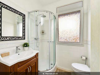 Step into this beautifully appointed bathroom, featuring a sleek corner shower with chrome fixtures and a convenient handheld showerhead.