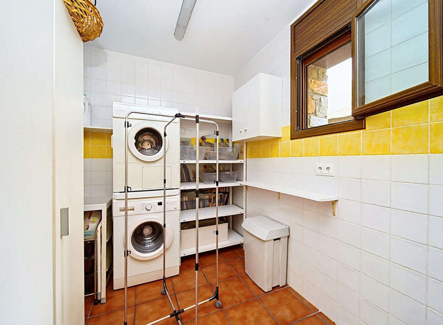 This laundry room features a stacked washer and dryer for efficient use of space.