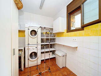 This laundry room features a stacked washer and dryer for efficient use of space.
