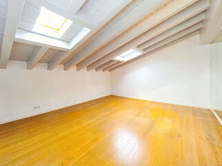 Discover this bright and airy attic space, featuring a stunning vaulted ceiling with exposed white beams and multiple skylights that flood the room with natural light.