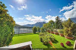 Enjoy breathtaking mountain and lake views from this stunning property's meticulously manicured lawn and garden.