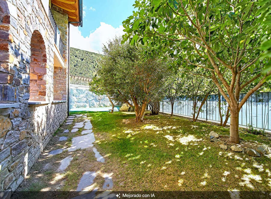 Discover this charming property featuring a beautiful stone facade and an arched entryway, leading to a lush green garden.
