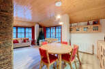 Experience cozy living in this charming dining and living area, featuring a warm wooden ceiling and walls, complemented by a stone accent wall.
