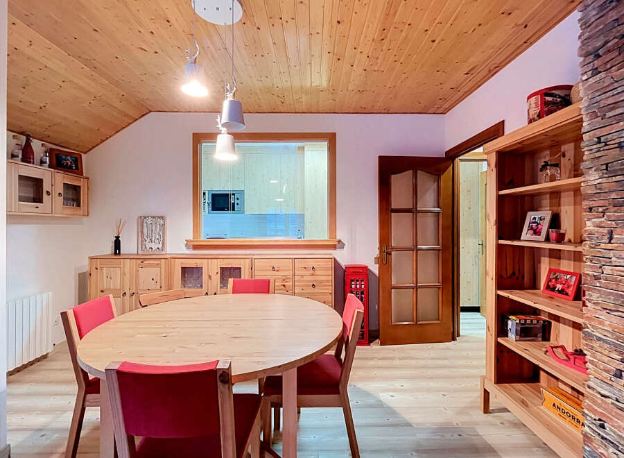 Experience cozy living in this charming dining room, featuring a warm wooden ceiling and walls that create a rustic ambiance.