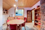 Experience cozy living in this charming dining room, featuring a warm wooden ceiling and walls that create a rustic ambiance.