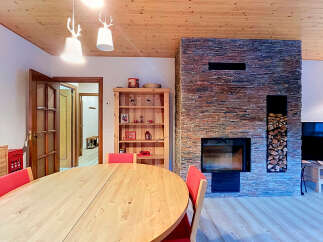 Experience cozy living in this charming dining area, featuring a spacious wooden table with vibrant red chairs perfect for family gatherings.
