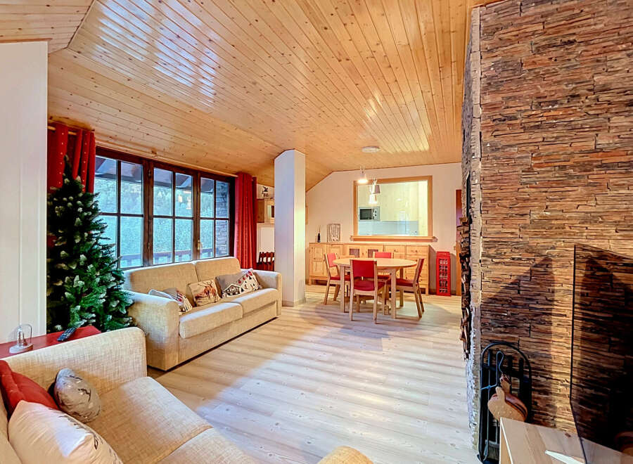 Experience cozy living in this charming mountain retreat, featuring a spacious living area with a stone fireplace and a dining nook perfect for family gatherings.