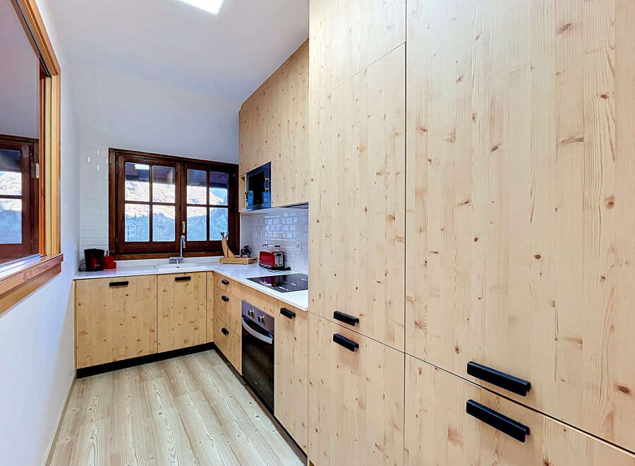 Discover this charming kitchen featuring light wood cabinetry and a sleek white countertop.
