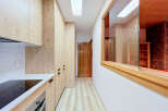 Discover a modern kitchen with light wood cabinetry and sleek white countertops, perfect for culinary adventures.