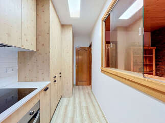 Discover a modern kitchen with light wood cabinetry and sleek white countertops, perfect for culinary adventures.