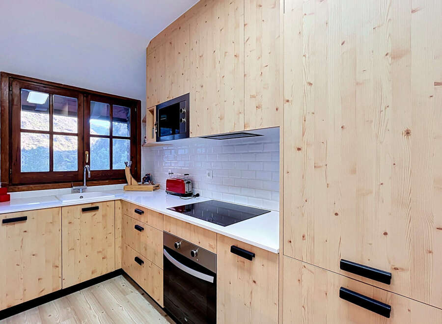 Experience the warmth and natural beauty of this kitchen, featuring custom light wood cabinetry that extends from floor to ceiling.