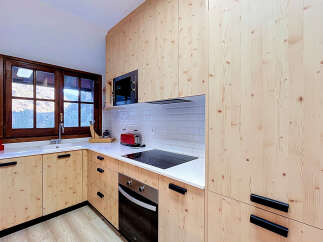 Experience the warmth and natural beauty of this kitchen, featuring custom light wood cabinetry that extends from floor to ceiling.