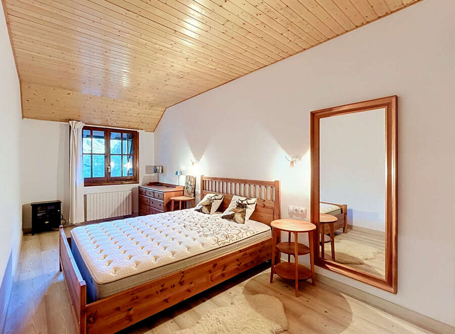Experience rustic charm in this cozy bedroom featuring a beautiful wooden bed and matching furniture.