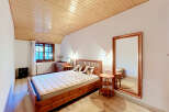 Experience rustic charm in this cozy bedroom featuring a beautiful wooden bed and matching furniture.