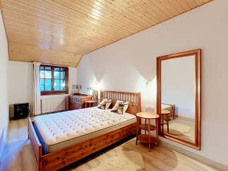 Experience rustic charm in this cozy bedroom featuring a beautiful wooden bed and matching furniture.