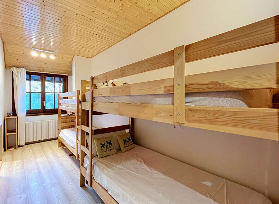 This charming bedroom features a set of sturdy wooden bunk beds, perfect for accommodating multiple guests.