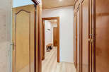 Step into this charming hallway featuring elegant wooden doors and built-in closets, offering ample storage and a warm, inviting aesthetic.