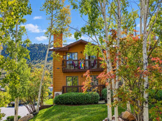 Nestled amidst vibrant autumn foliage, this charming wooden house offers a picturesque mountain retreat.