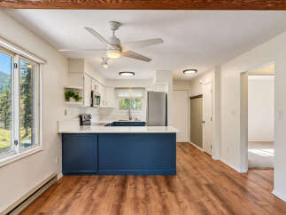 Discover this charming kitchen featuring a sleek navy blue island and white countertops, perfect for meal prep and casual dining.