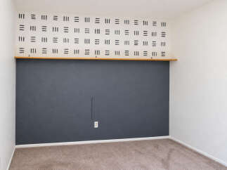 This room features a unique accent wall with a repeating black dash pattern above a dark gray painted section.