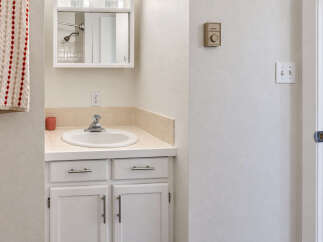 This bathroom features a clean white vanity with ample storage and a tiled backsplash.