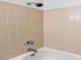 Step into a clean and functional bathroom featuring a classic tiled shower and tub combination.