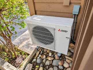 This property features a modern Mitsubishi Electric outdoor air conditioning unit, ensuring efficient climate control for your home.