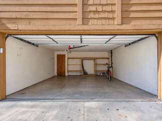 Discover ample storage and organization in this spacious garage, featuring built-in shelving perfect for tools and supplies.