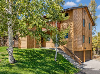 Nestled amidst lush greenery, this charming wooden home offers a serene retreat.