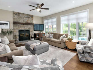 This inviting living room features a stunning floor-to-ceiling stone fireplace, perfect for cozy evenings.
