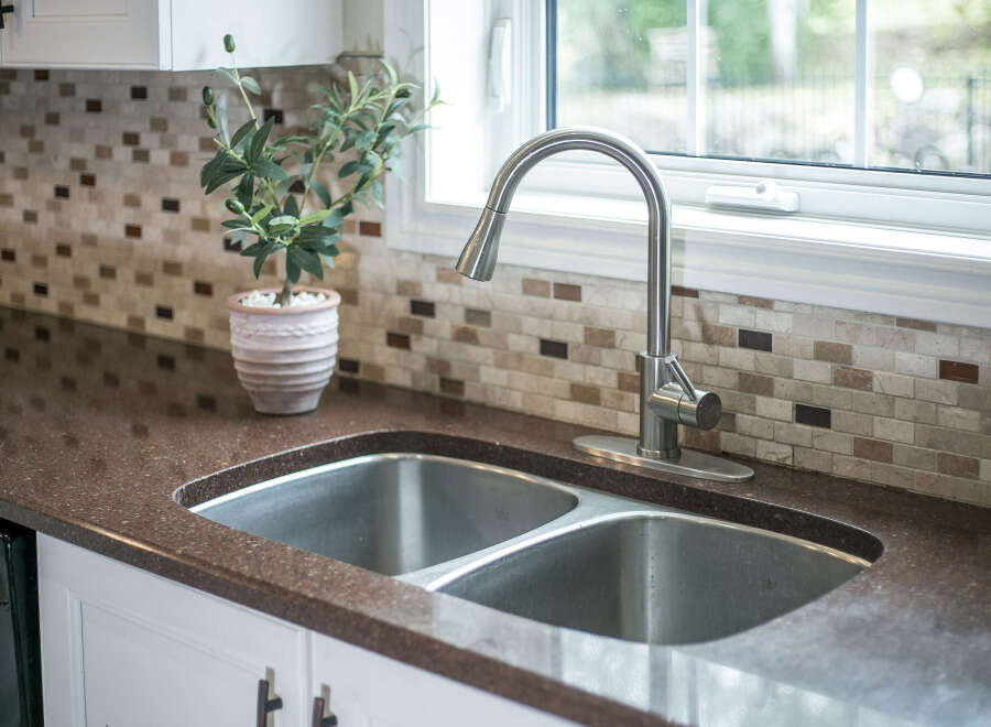 Experience the elegance of this kitchen, featuring a stunning dual-basin stainless steel sink complemented by a sleek, modern faucet.