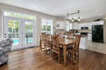 This spacious open-concept home features a bright dining area with a large wooden table, perfect for family gatherings.