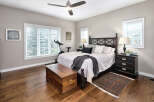 This inviting bedroom features a spacious king-size bed with a dark wood headboard, complemented by plush white bedding and decorative pillows.