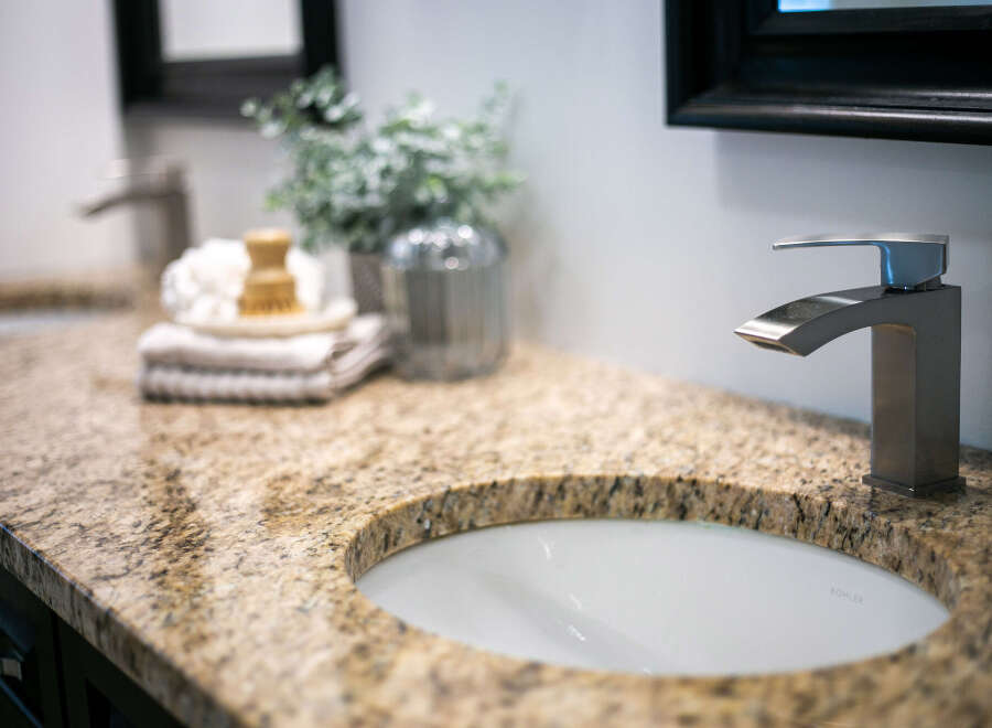 Experience luxury in this master bathroom, featuring a stunning granite countertop with a double sink setup.