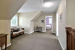 This charming attic space offers a cozy seating area with a daybed and decorative pillows, perfect for relaxation.
