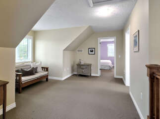 This charming attic space offers a cozy seating area with a daybed and decorative pillows, perfect for relaxation.