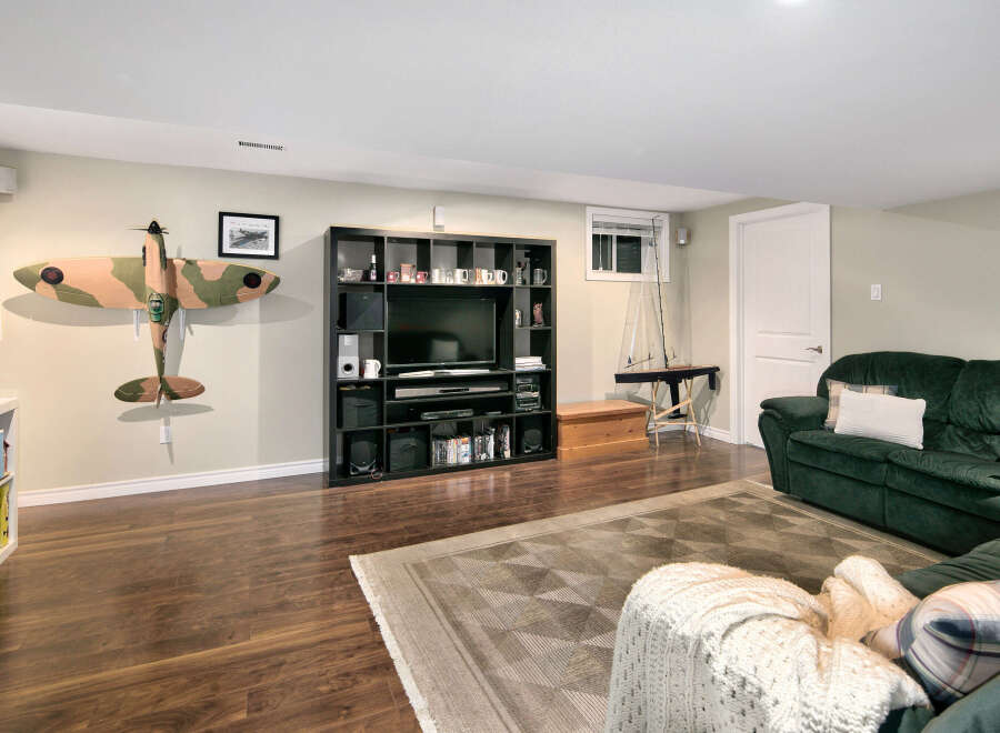 This basement living area features a large entertainment unit with a flat-screen TV and ample storage for media.